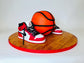 Basketball and red sneakers on a wooden platform with a white background