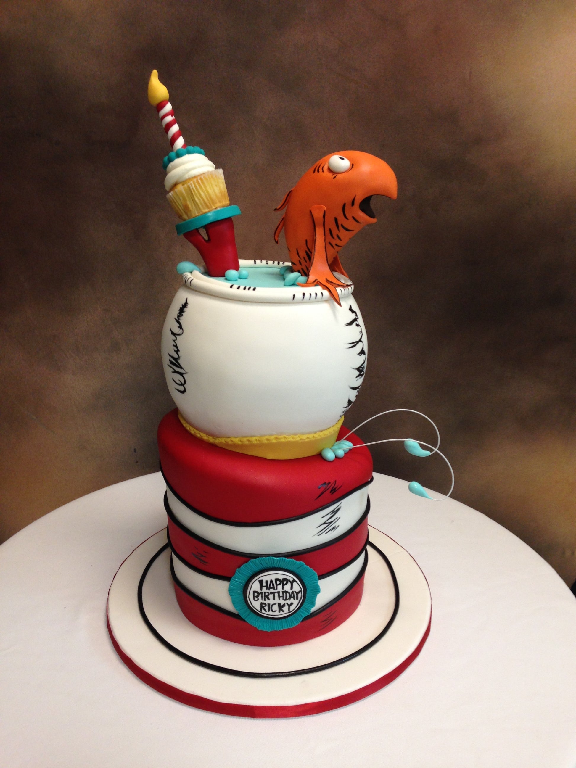 Colorful cake with a bird and cup design on a brown background