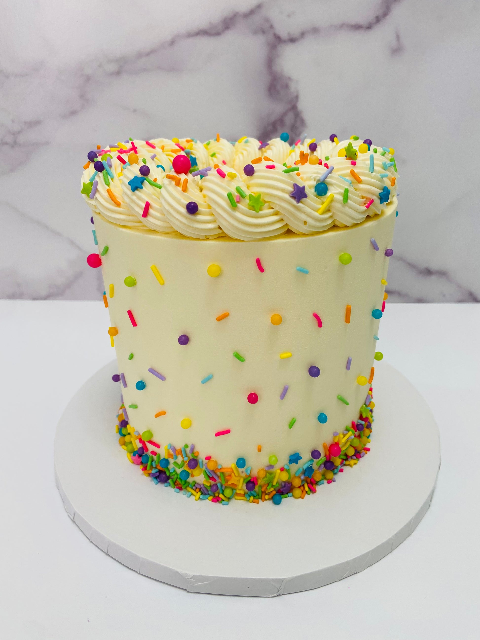 Colorful sprinkled cake on a marble background