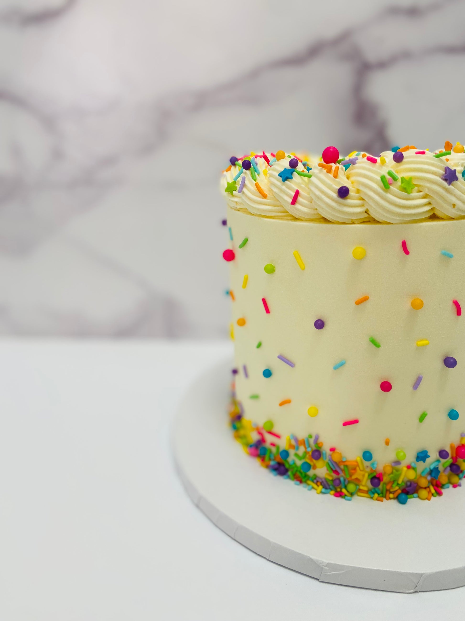 Cake with colorful sprinkles on a marble surface