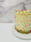 Cake with colorful sprinkles on a marble surface