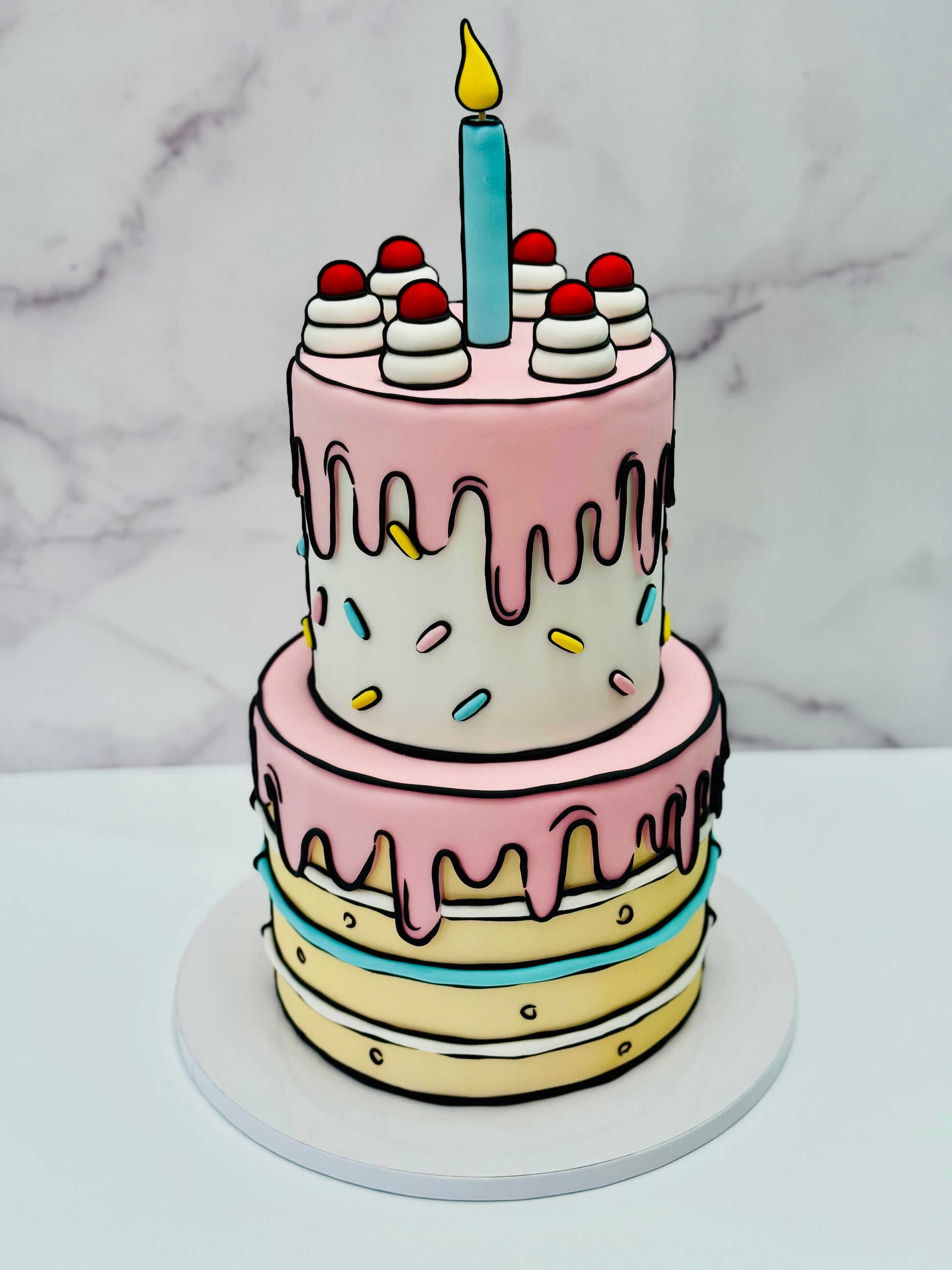Two-tiered birthday cake with pink and white frosting, colorful sprinkles, and a single candle on a marble background.