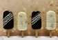 Four ice cream cakesicles with decorative patterns on a blurred background