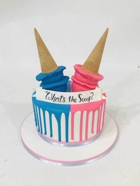 Two-toned ice cream cake with blue and pink colors and ice cream cones on top.