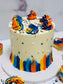 Colorful cake with blue, orange, and yellow icing on a white background