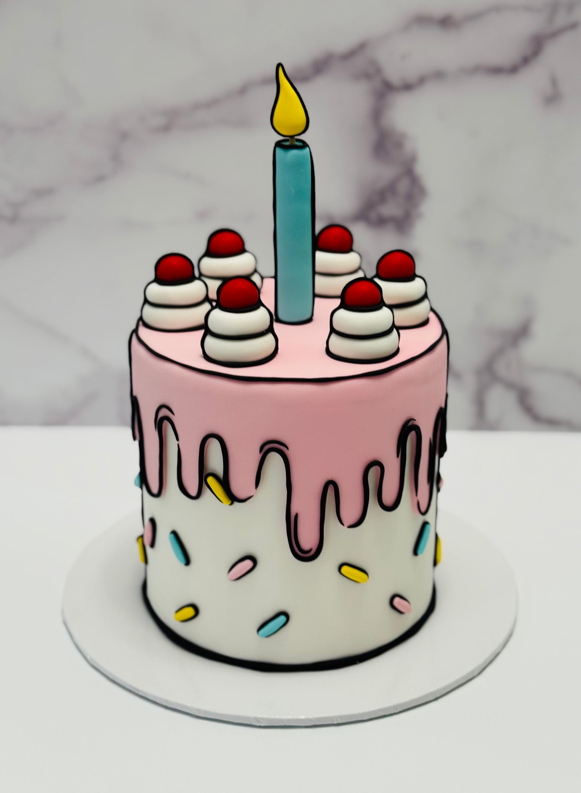 Small birthday cake with pink drip design, colorful sprinkles, and a single candle on a marble background.