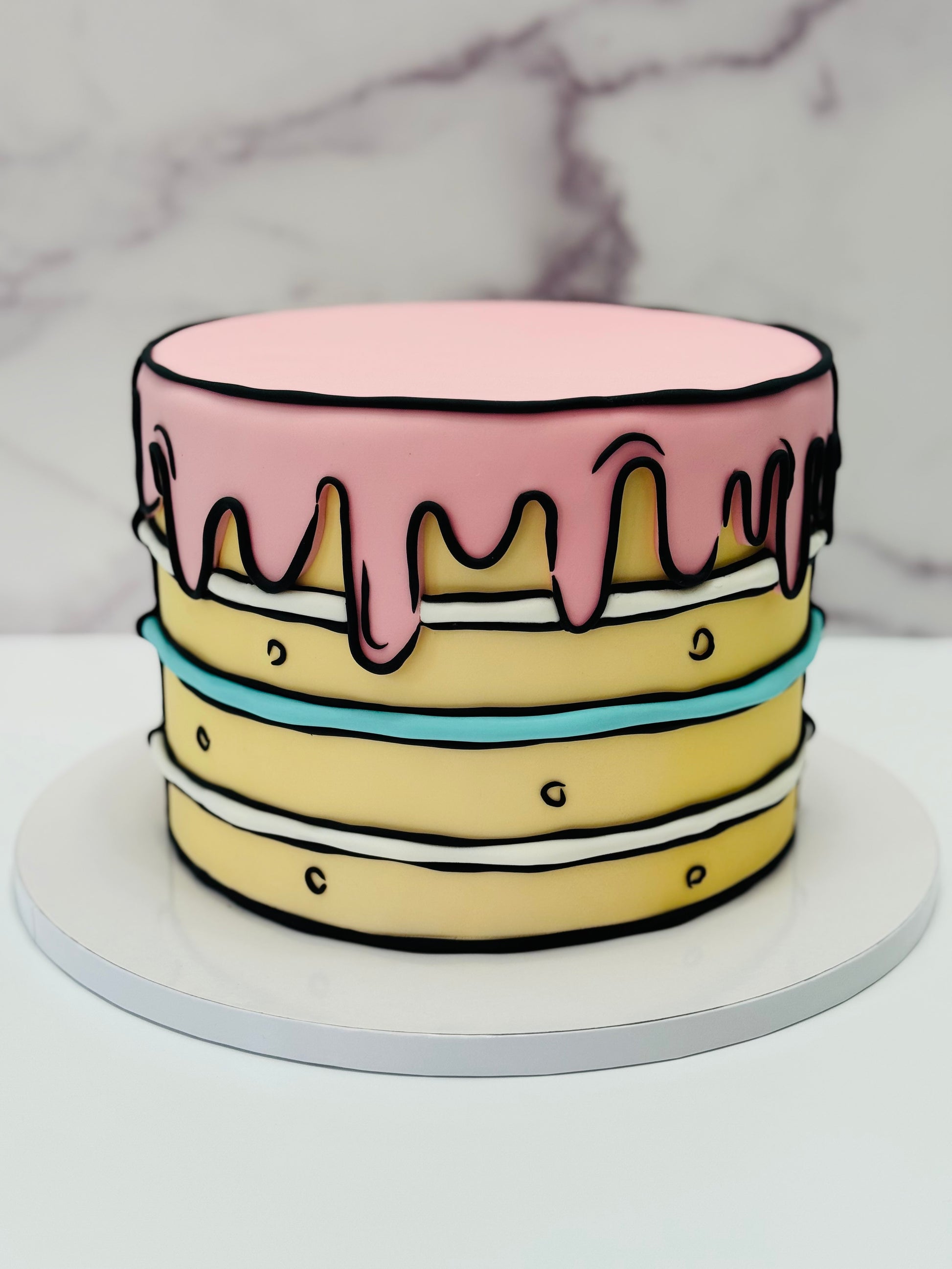 Two-layer cake with pink and blue icing on a marble background
