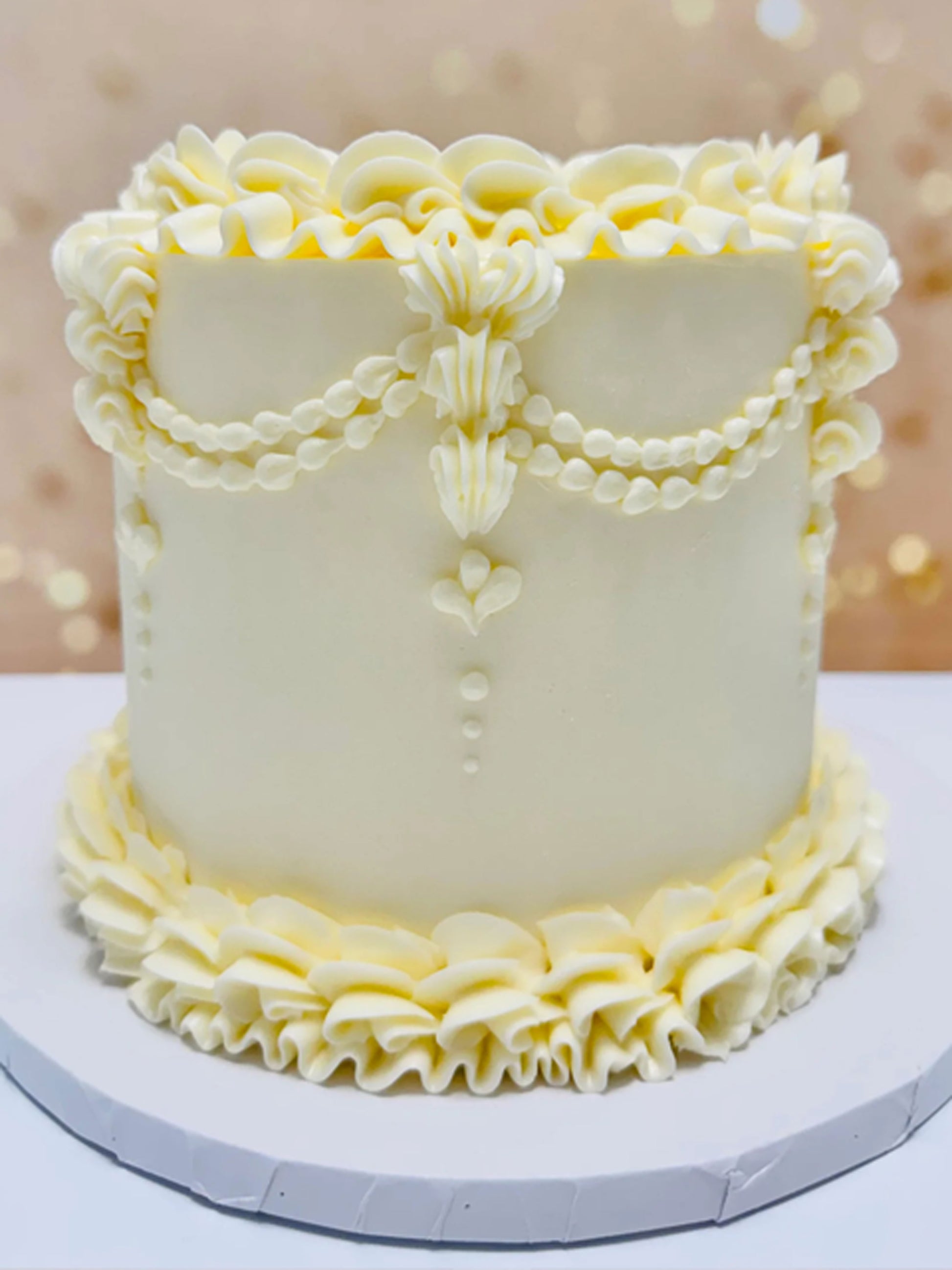 White cake with decorative ruffles on a blurred background